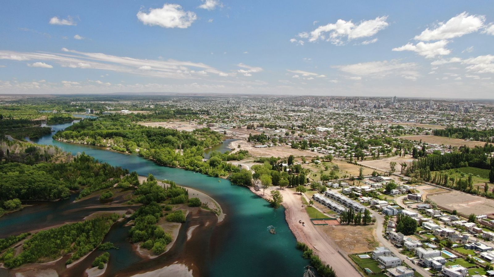 Vista aérea del río Limay y Neuquén Capital, con el Paseo de la Costa y barrios hacia el centro